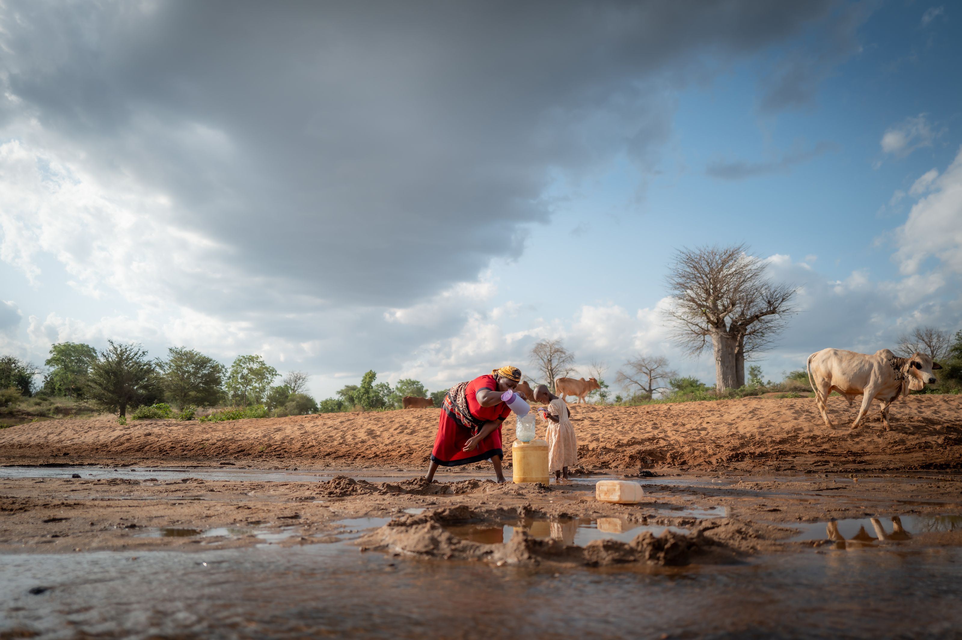 Woman and daughter collecting water.